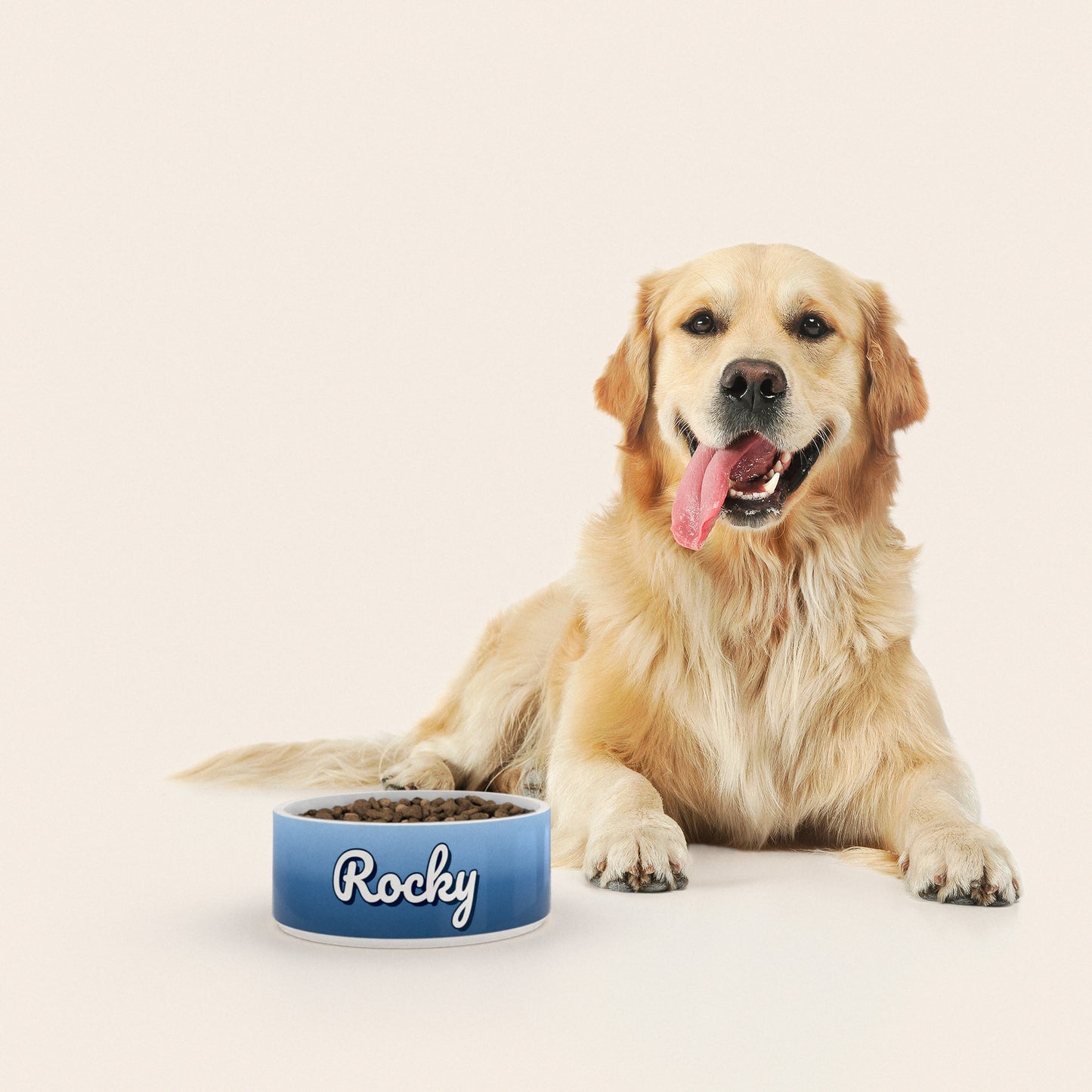 Un golden retriever assis à côté d'un bol pour chien au motif Duo Bleu personnalisé avec le nom ROCKY