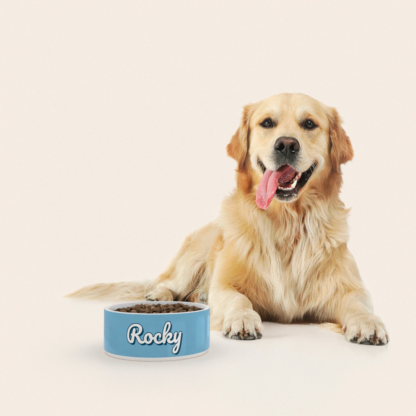 Un golden retriever assis à côté d'un bol pour chien au motif Bleu Pastel personnalisé avec le nom ROCKY