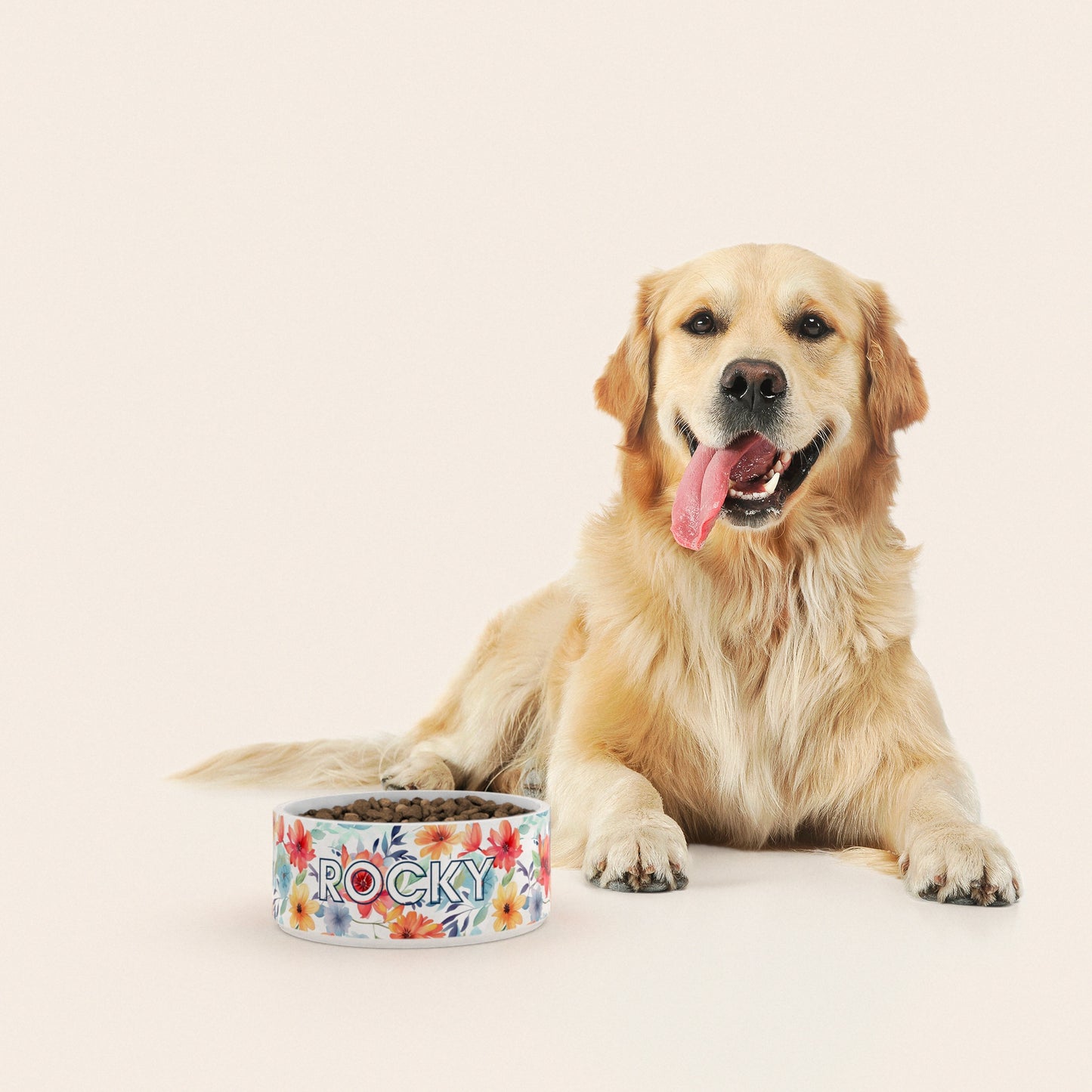 Un golden retriever assis à côté d'un bol pour chien au motif Printemps personnalisé avec le nom ROCKY