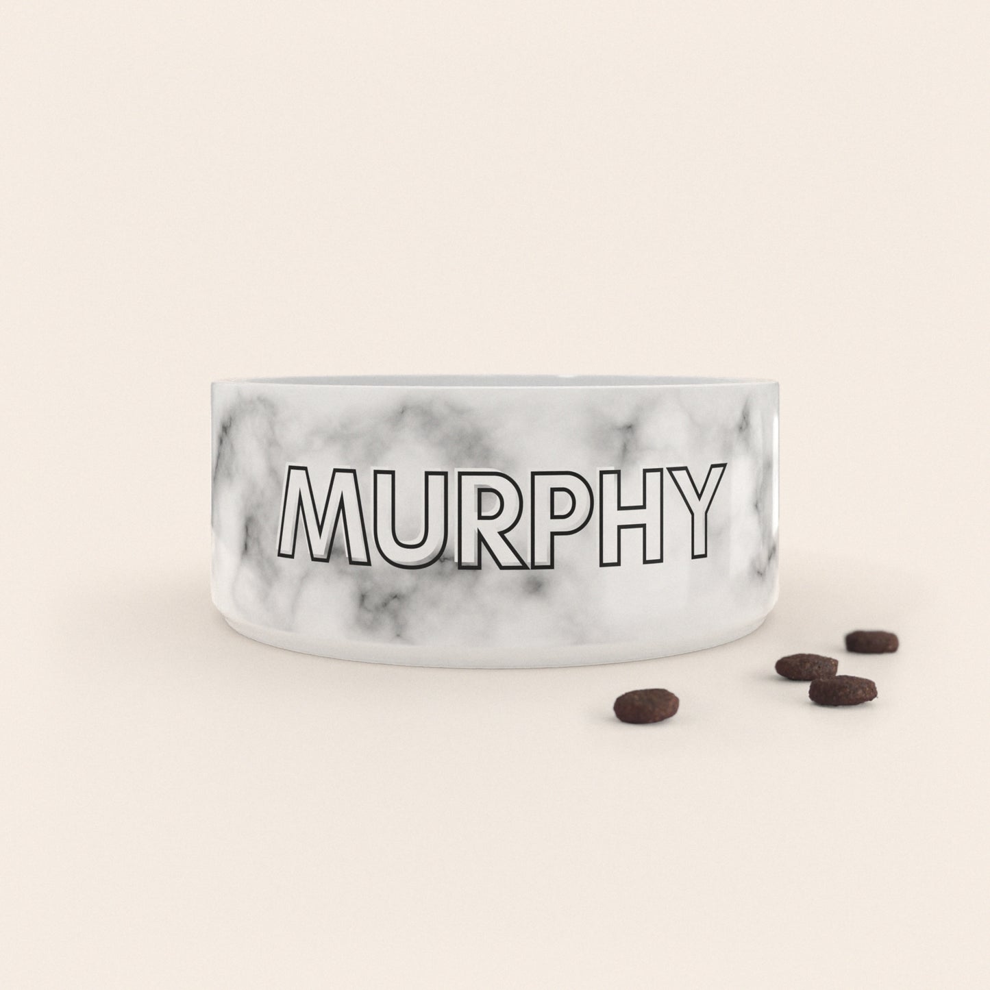 Gamelle pour chien au motif Marbre Blanc personnalisés avec le nom Murphy, accompagné de croquettes sur fond neutre.