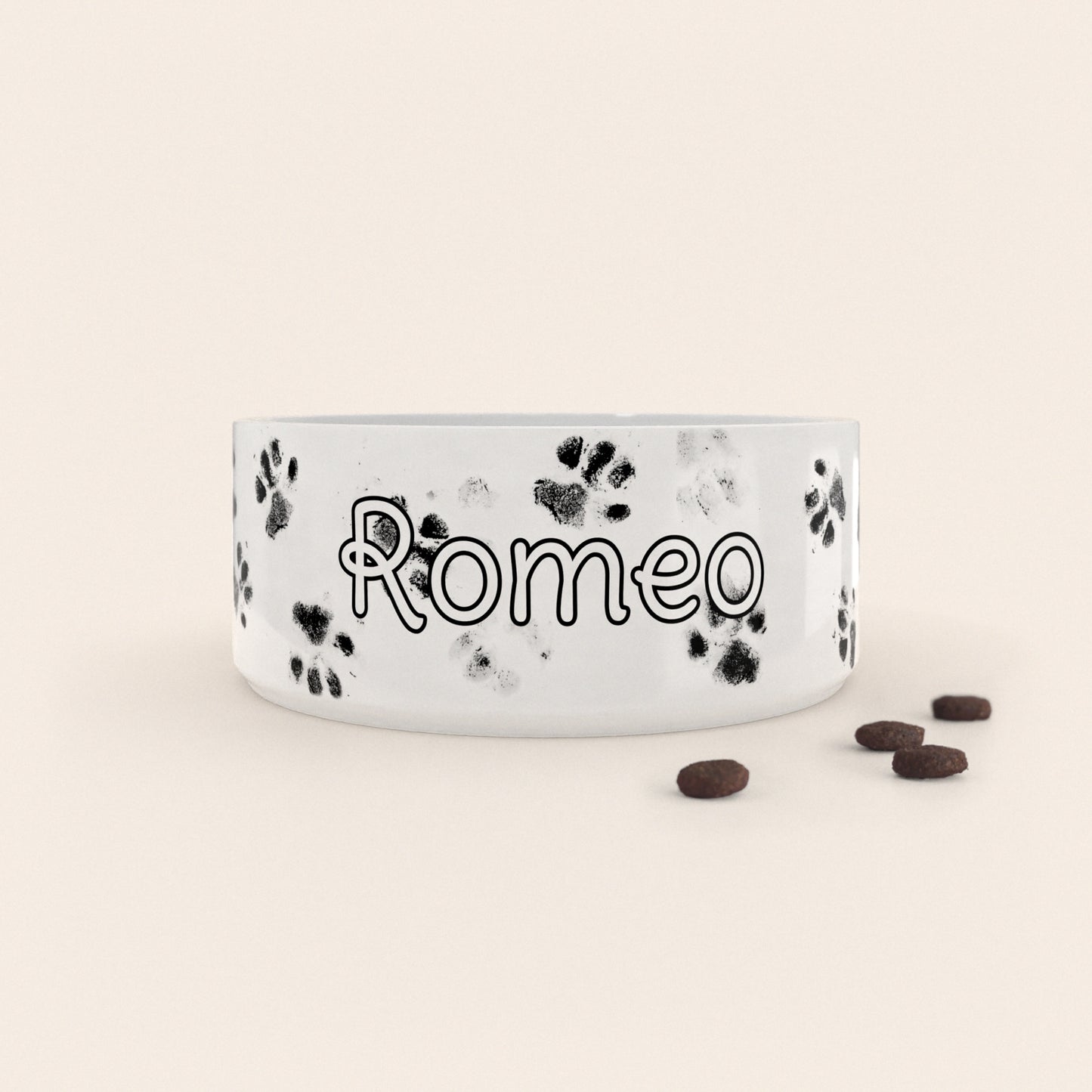 Gamelle pour chien au motif Pattes Noires personnalisés avec le nom Romeo, accompagné de croquettes sur fond neutre.