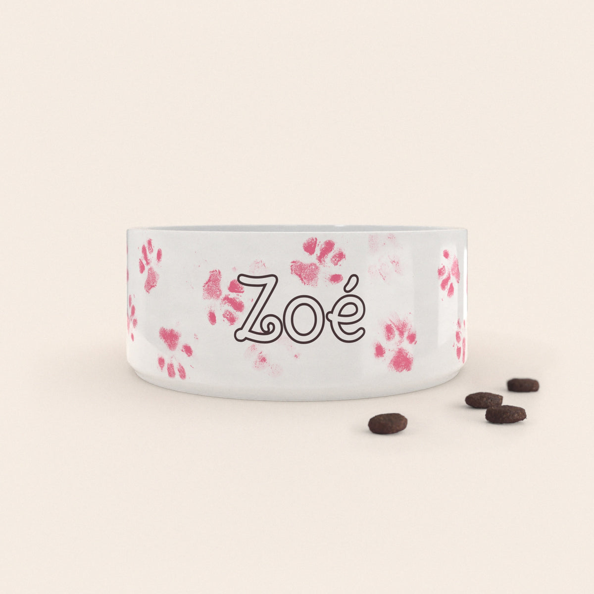 Gamelle pour chien au motif Pattes Roses personnalisés avec le nom Zoé, accompagné de croquettes sur fond neutre.