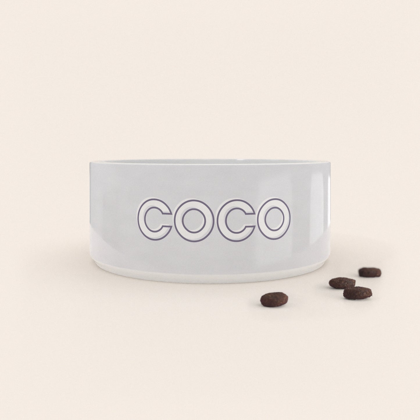 Gamelle pour chien au motif Gris Pastel personnalisés avec le nom Coco, accompagné de croquettes sur fond neutre.