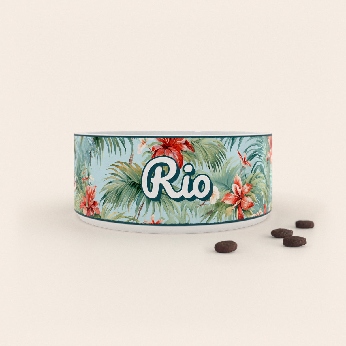 Gamelle pour chien au motif Hawaï personnalisés avec le nom Rio, accompagné de croquettes sur fond neutre.