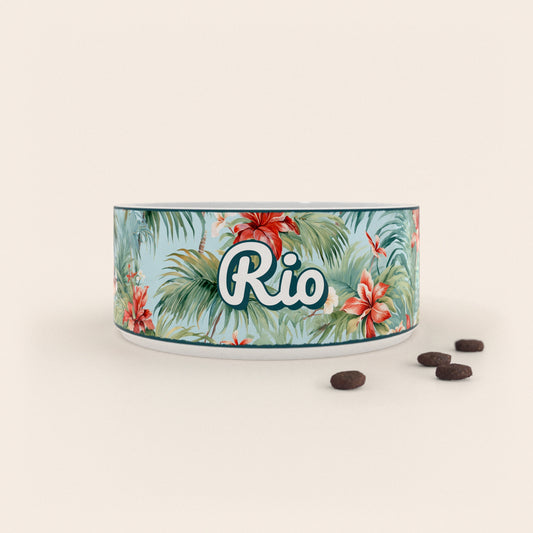 Gamelle pour chien au motif Hawaï personnalisés avec le nom Rio, accompagné de croquettes sur fond neutre.